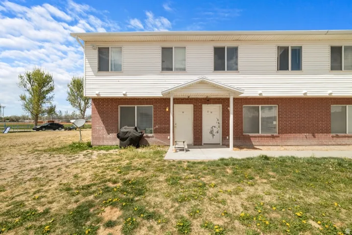 View of front of property with covered porch, a front lawn, and brick siding