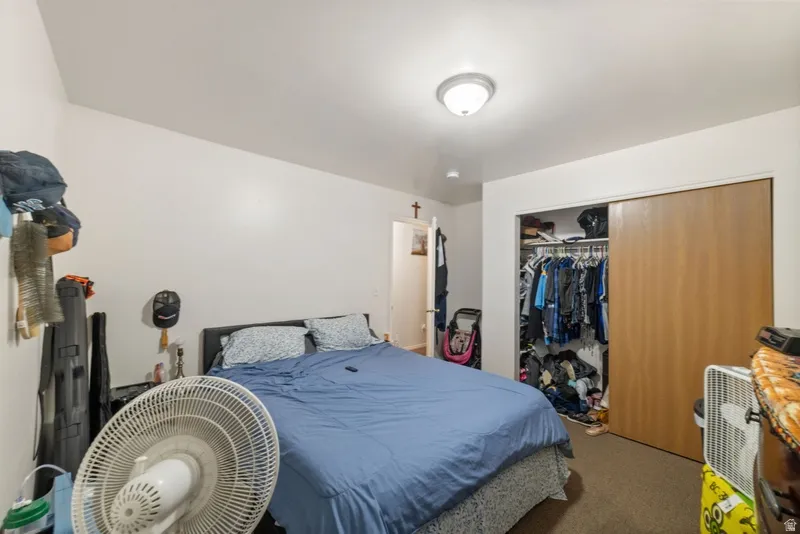 Bedroom featuring carpet and a closet