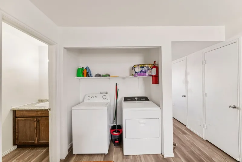 Laundry area featuring light wood-style floors and separate washer and dryer