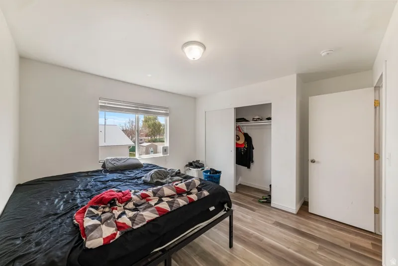Bedroom with light wood-type flooring and a closet