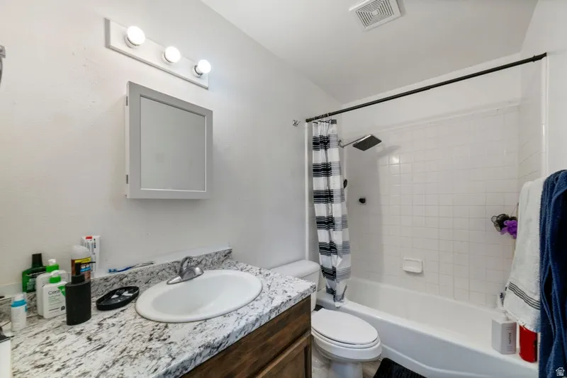 Full bathroom featuring vanity and shower / bathtub combination with curtain