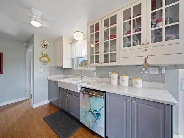 Updated Kitchen with two tone cabinets, quartz counters, glass fronted cabinets, dishwasher, and decorative backsplash