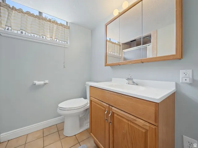 3/4 bathroom with vanity, light tile patterned floors, and a shower