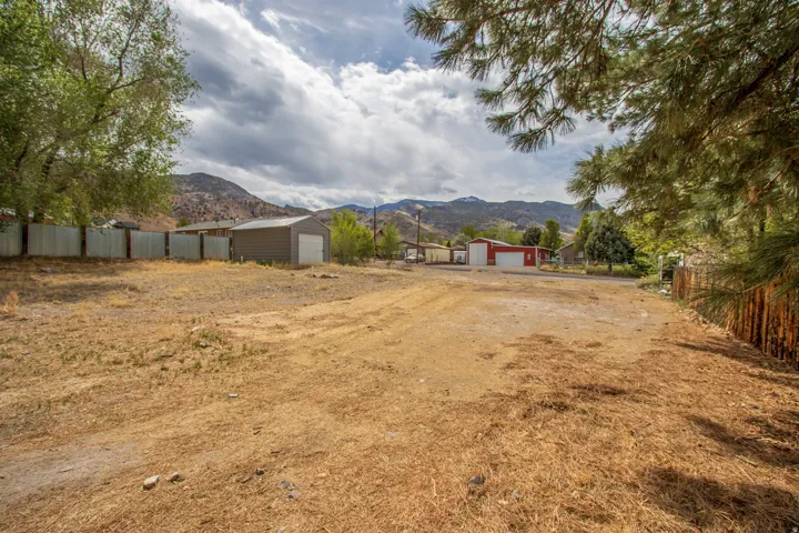View of yard with a mountain view, a detached garage, and an outdoor structure