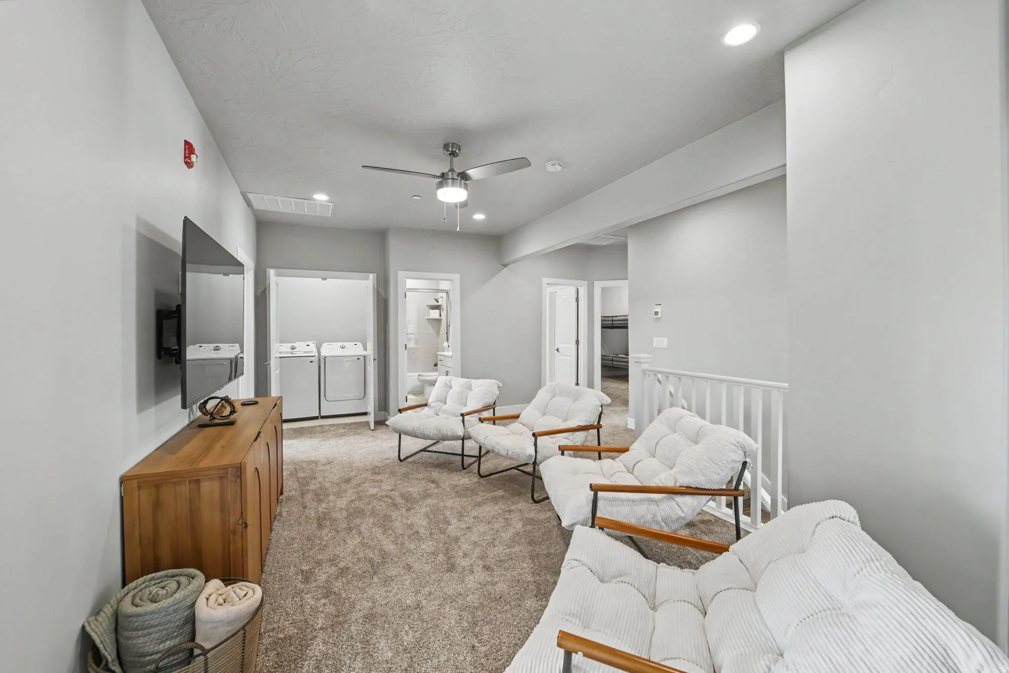 Recessed lighting, ceiling fan, carpet flooring, built-in laundry closet with appliances, and white railing
