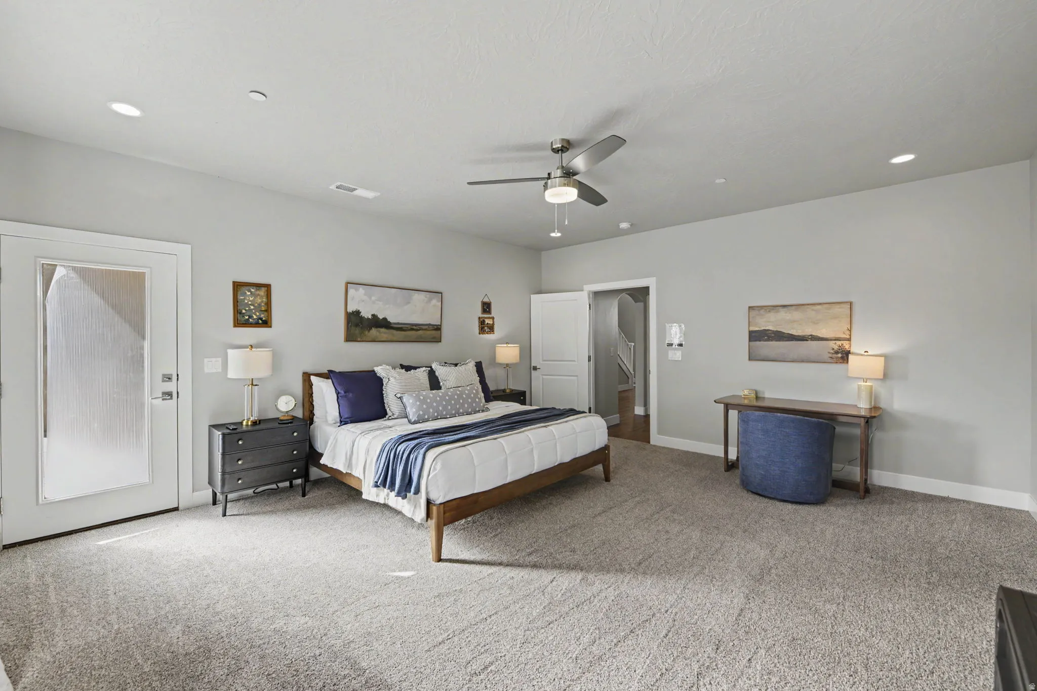 Spacious primary bedroom featuring neutral wall finishes, recessed ceiling lighting, and a ceiling fan