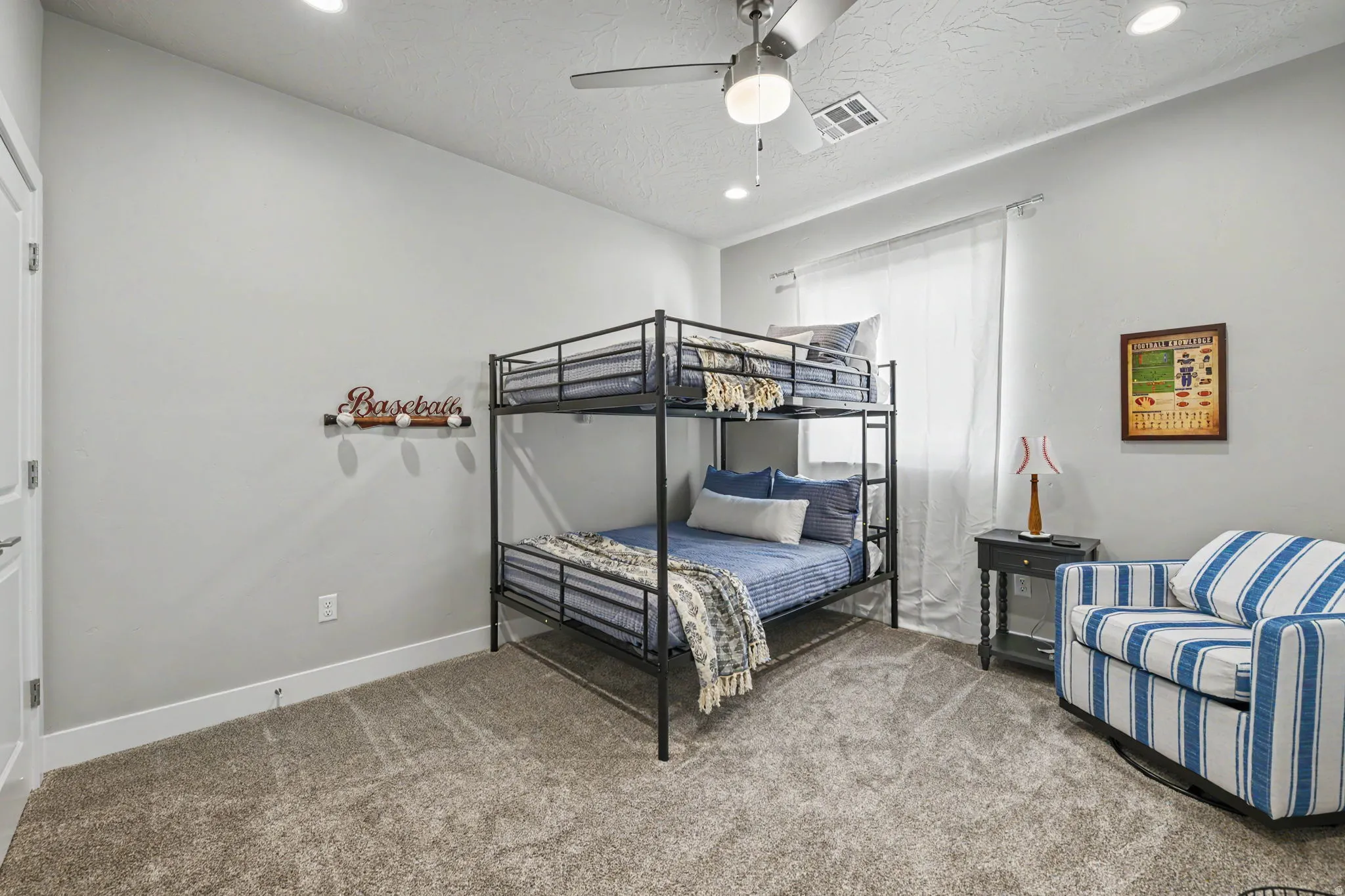 Plush carpeting, recessed ceiling lighting, a ceiling fan, and window treatments