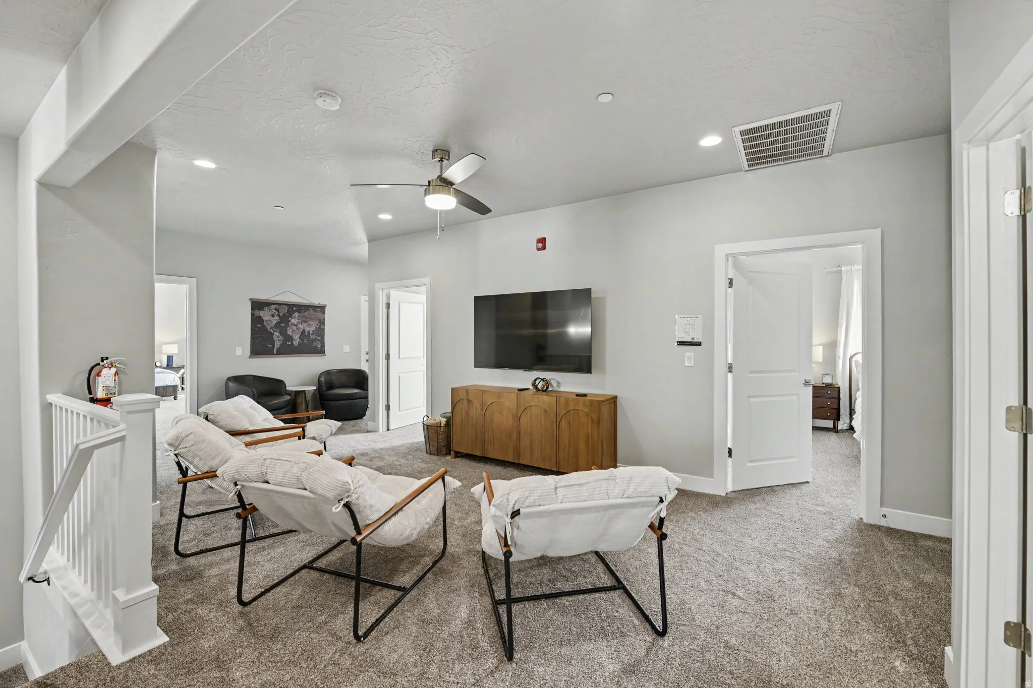 Recessed lighting, ceiling fan, carpeted flooring, white trim, and a white interior railing