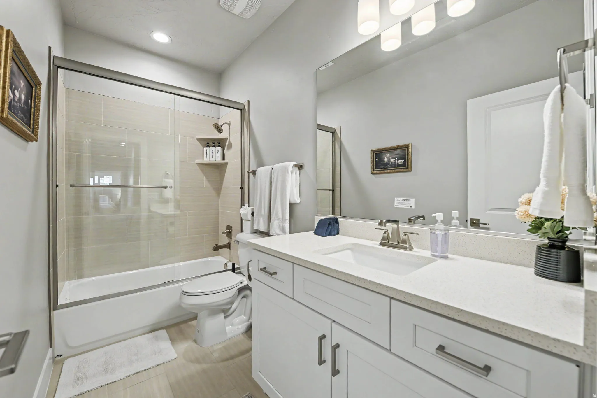 White shaker-style vanity with a light-toned countertop, undermount sink, and brushed nickel faucet