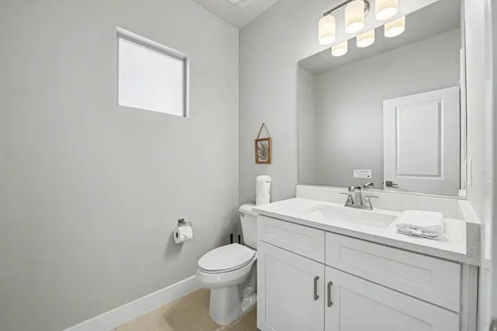 White vanity with brushed nickel hardware, integrated rectangular sink, and light-toned countertop
