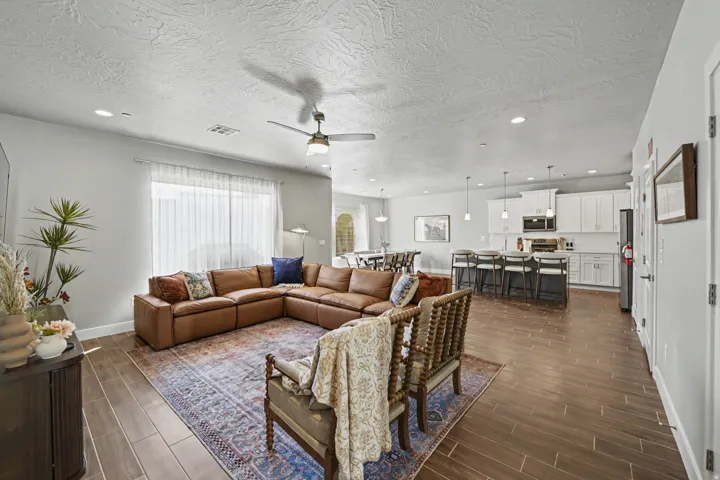 Open-concept living space featuring wood-finish flooring, recessed lighting, and a ceiling fan
