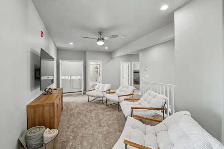 Recessed lighting, ceiling fan, carpet flooring, built-in laundry closet with appliances, and white railing