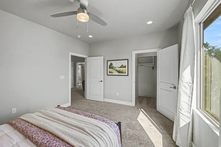 Carpeted room featuring a ceiling fan with integrated lighting, recessed lighting, and a window