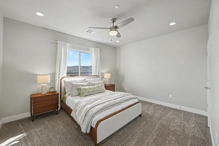 Recessed lighting, ceiling fan, window with white curtains, gray carpeting, and light gray wall paint