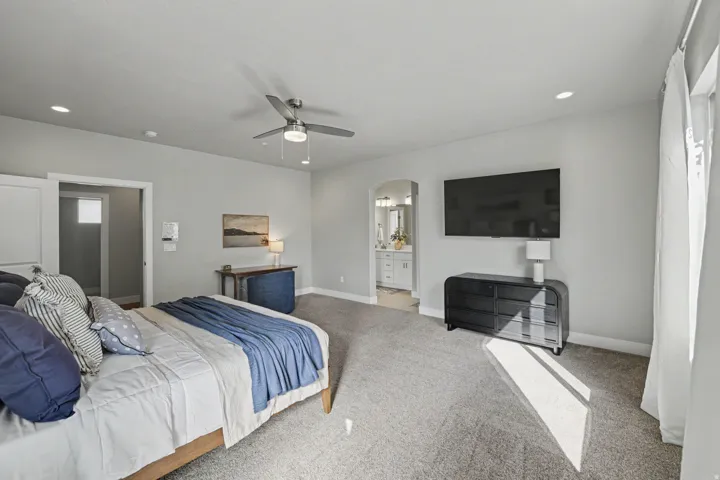 Recessed lighting, ceiling fan, and light gray carpet