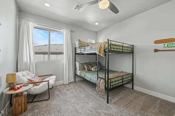 Recessed lighting, ceiling fan fixture, large window with drapes, and wall-to-wall carpeting