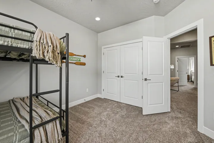 Neutral wall paint, carpet flooring, built-in closet with double panel doors, recessed lighting, and a white trim package