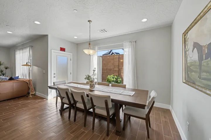 Wood-finish flooring, recessed lighting, and a frosted glass door with a transom window