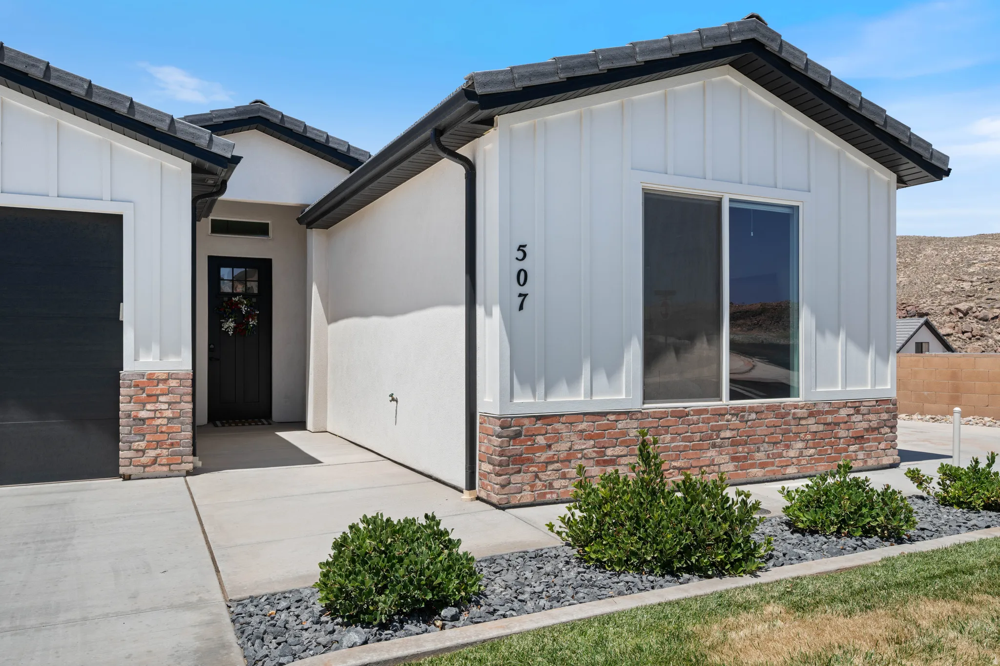 View of exterior entry featuring board and batten siding, an attached garage, and a tiled roof