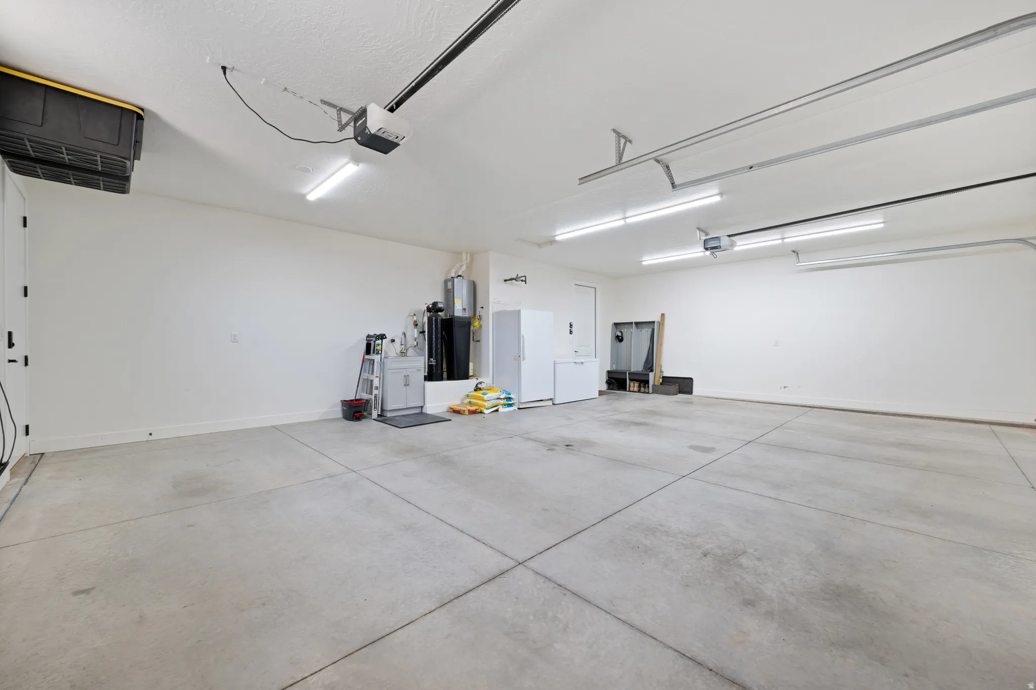 Garage featuring freestanding refrigerator and a garage door opener