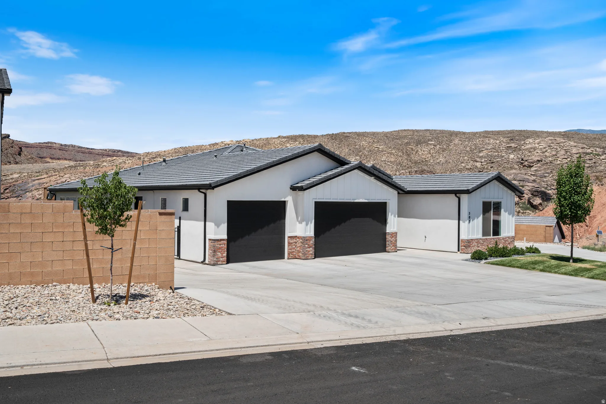 Ranch-style home with a garage, driveway, a mountain view, and a tiled roof