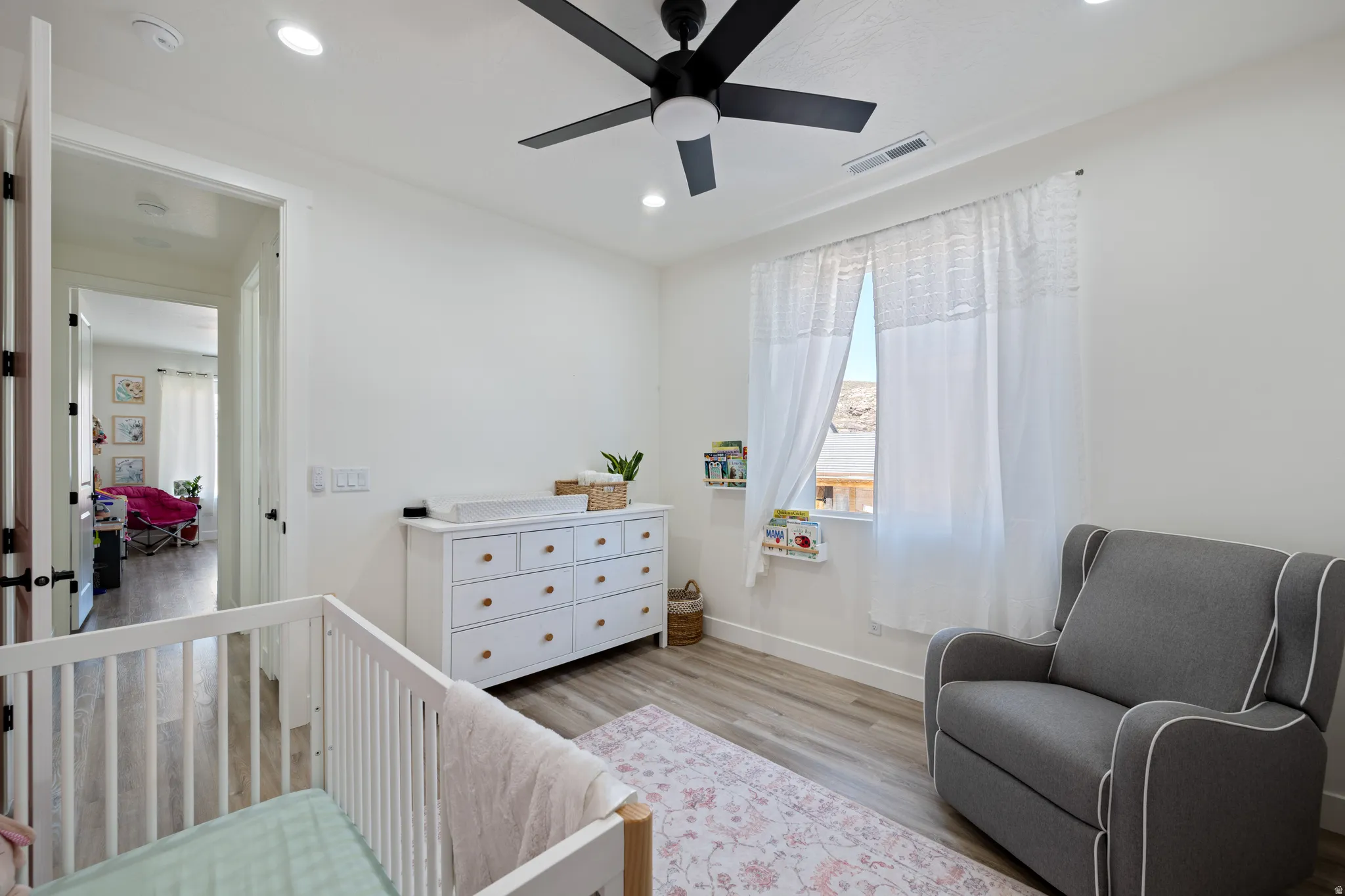 Bedroom featuring a nursery area, light wood-type flooring, recessed lighting, and ceiling fan