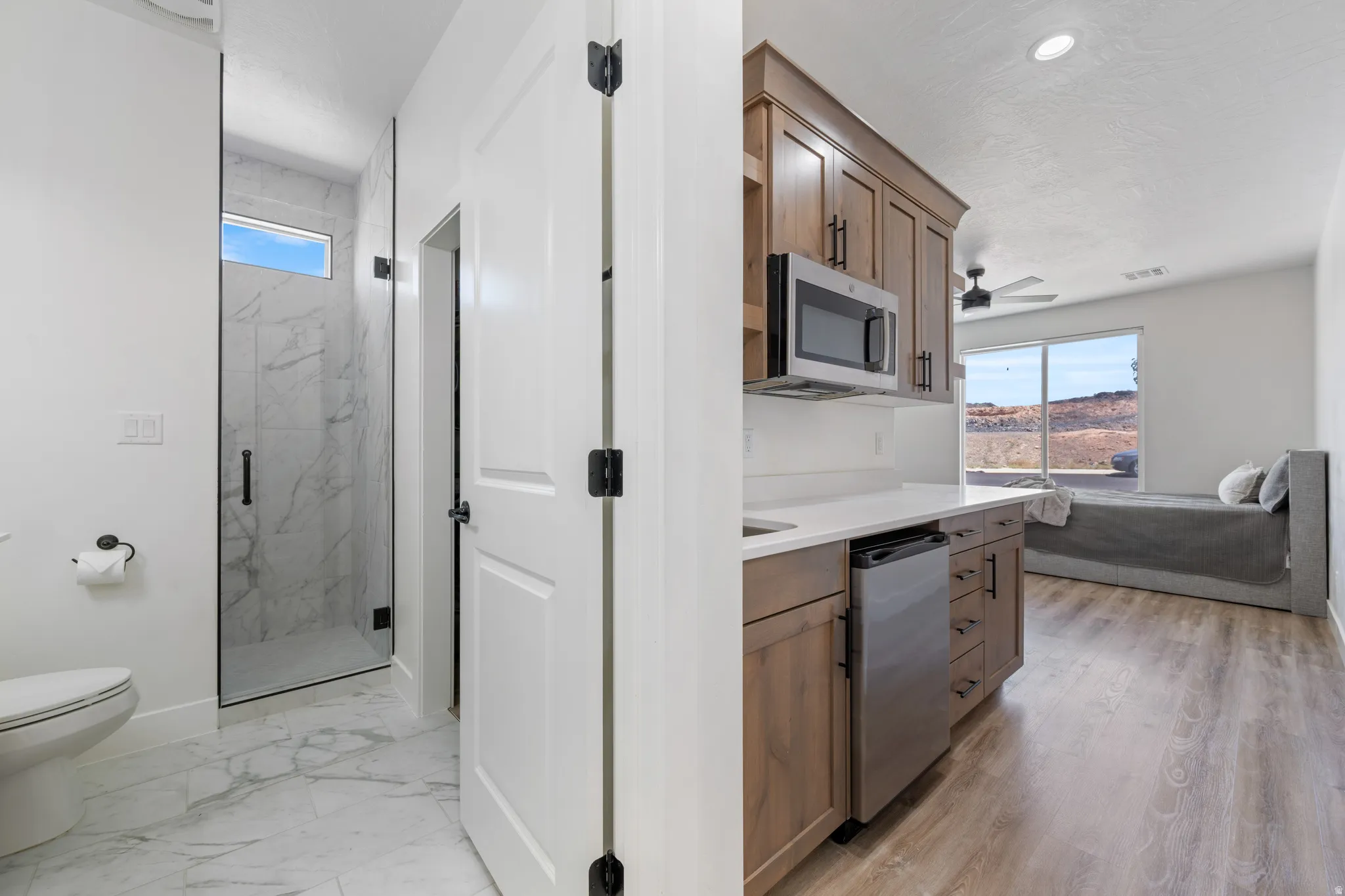 Kitchen with stainless steel appliances, wood finish cabinetry, and a ceiling fan