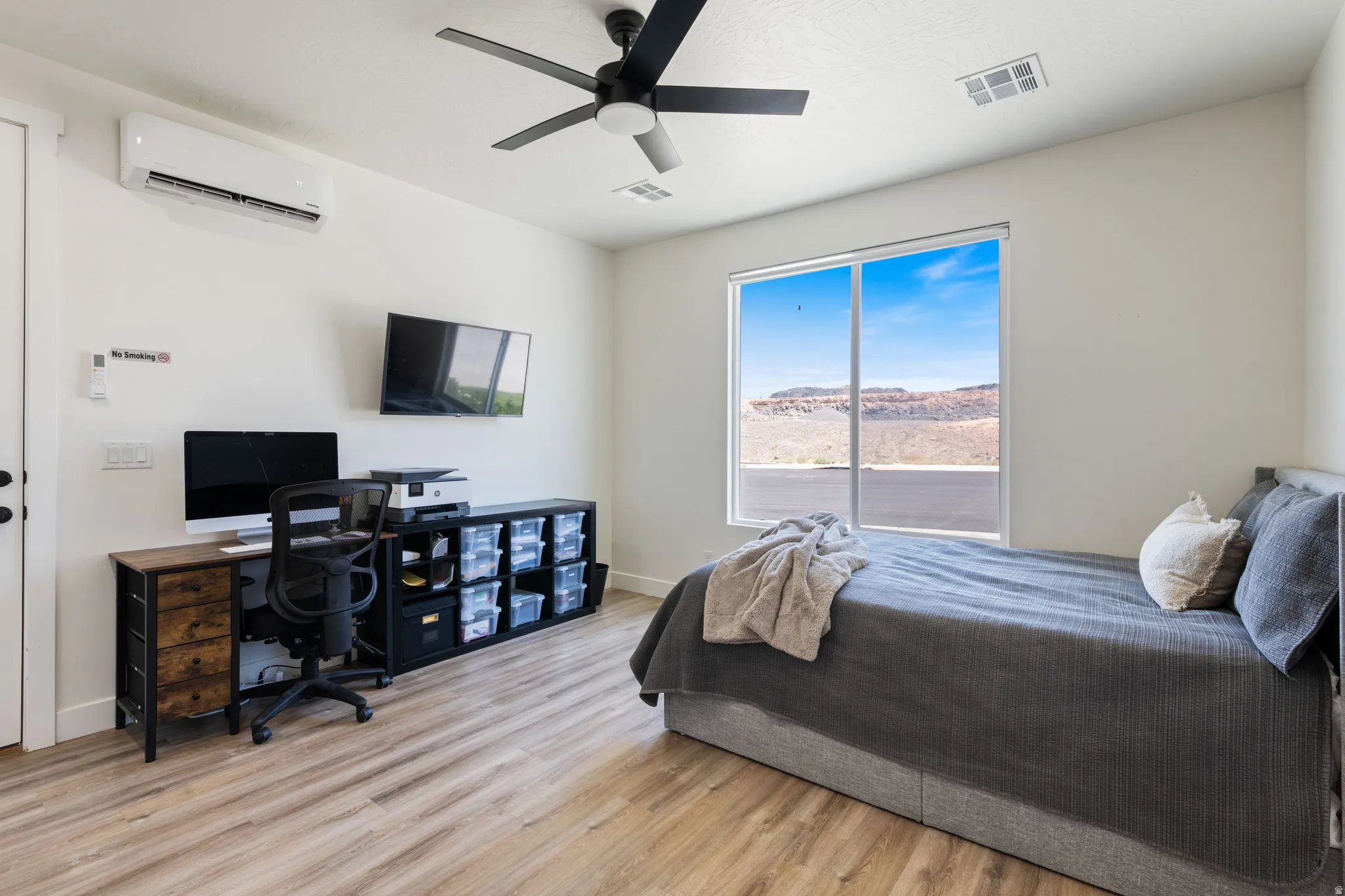 Bedroom featuring a desk, light wood-style floors, and a ceiling fan