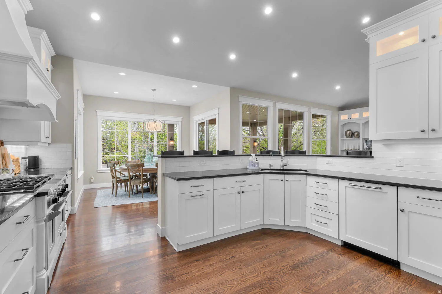 Kitchen featuring backsplash, white cabinetry, a peninsula, and dark wood finished floors