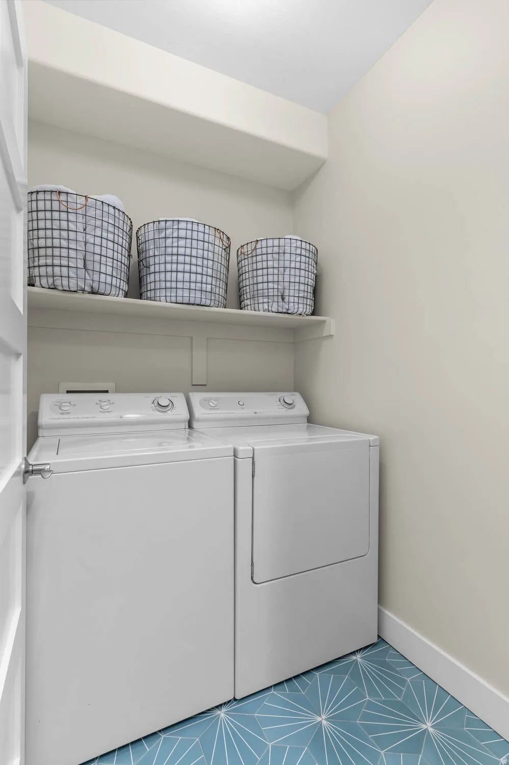 Laundry room with washing machine and clothes dryer and shelf