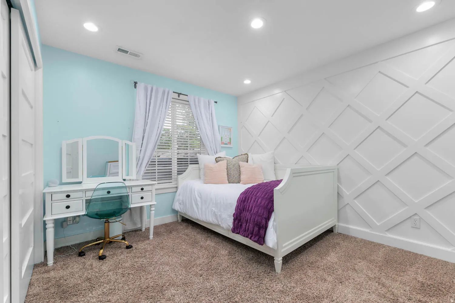 Carpeted bedroom featuring a decorative wall and recessed lighting