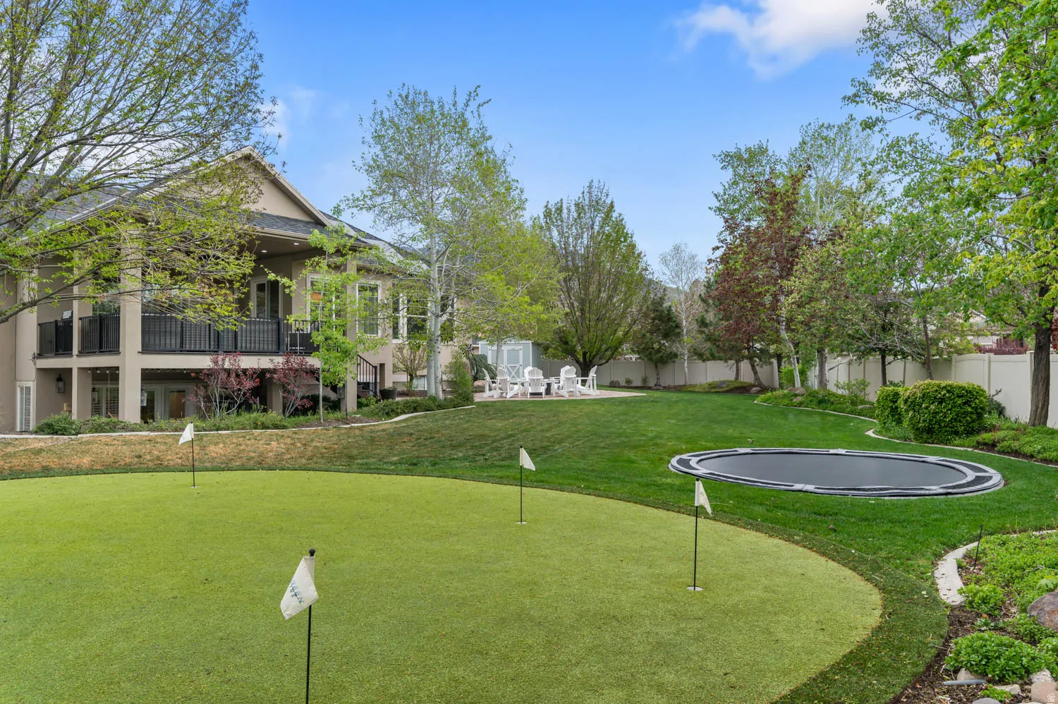Fenced yard featuring a putting area