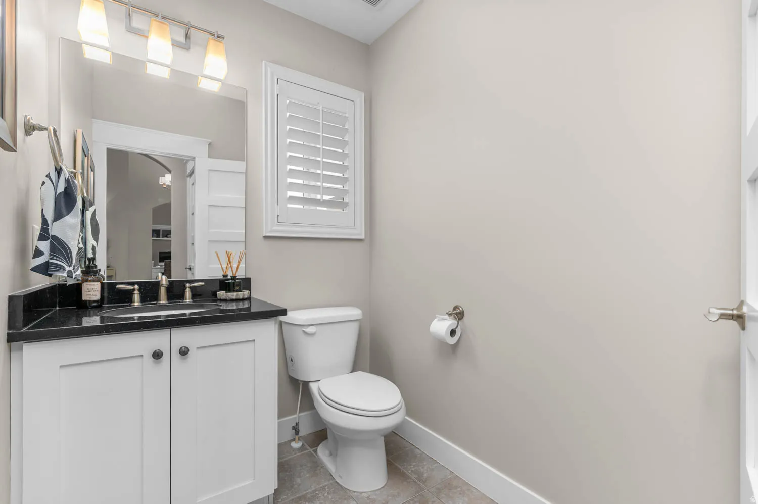 Half bathroom featuring vanity and light tile patterned flooring