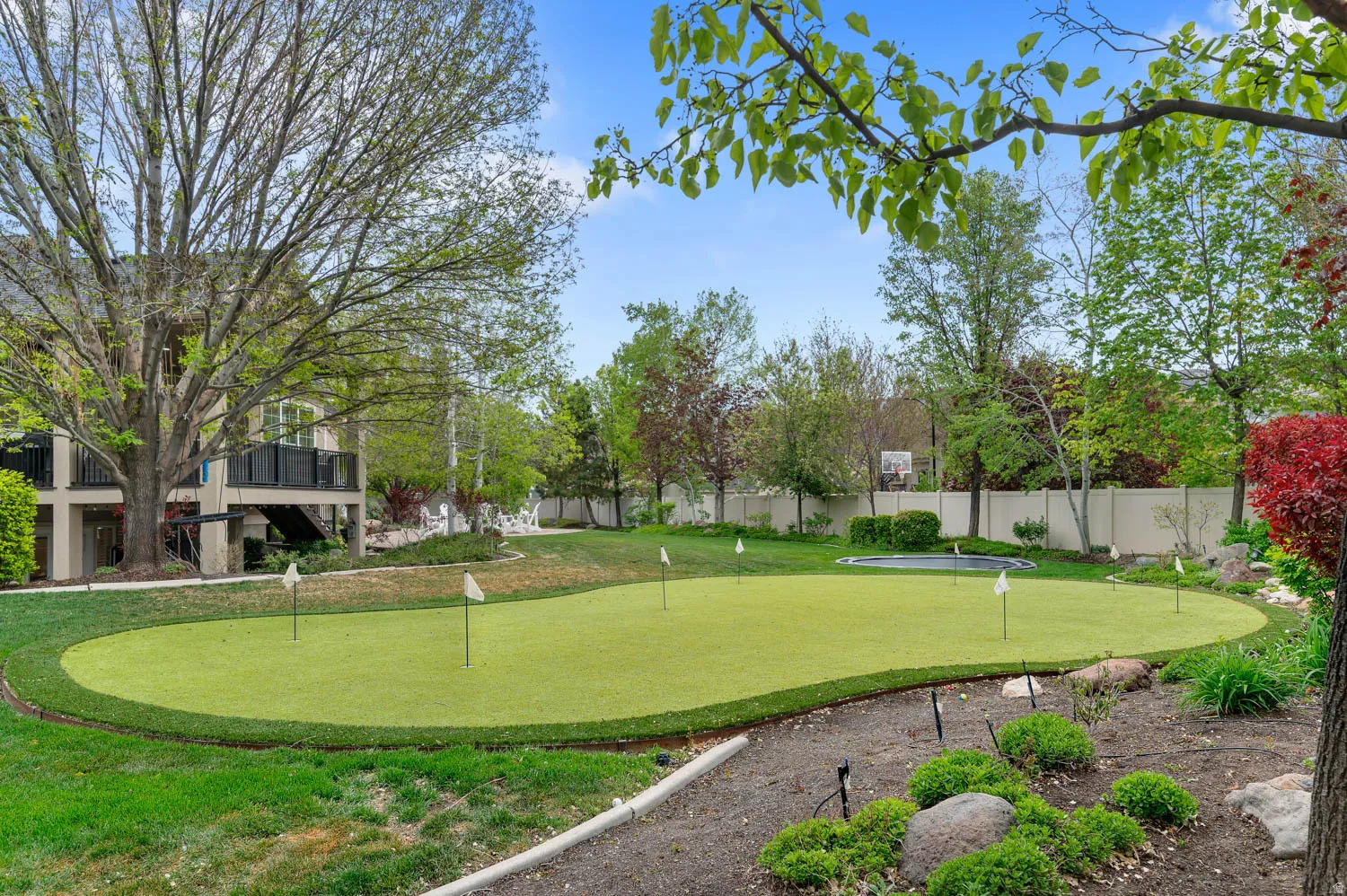 Fenced backyard with a putting area