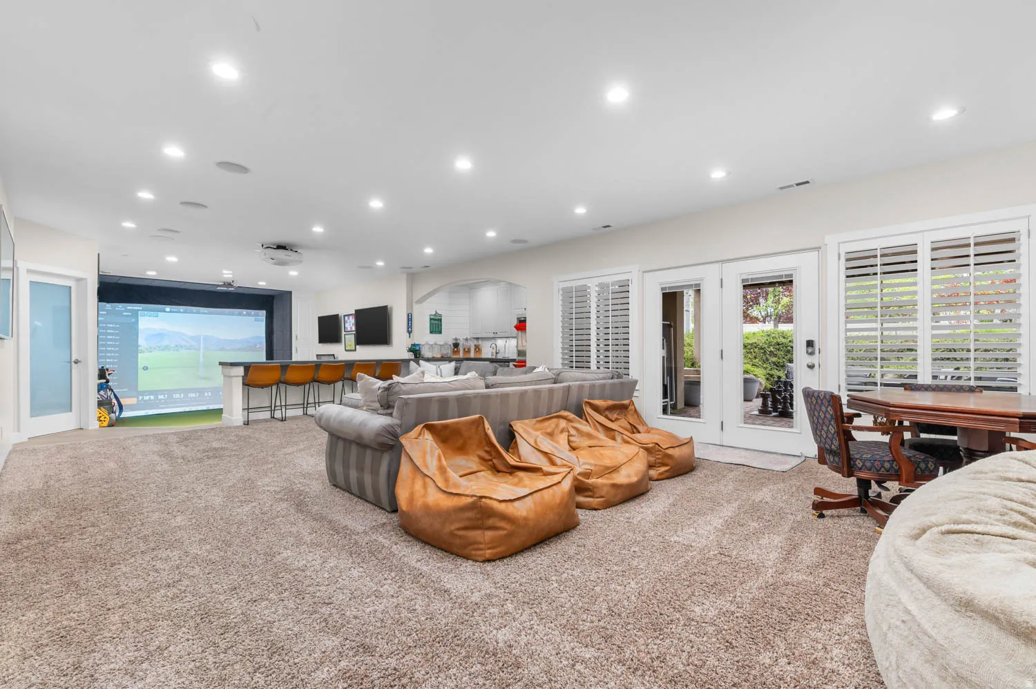 Living area featuring recessed lighting, light carpet, and golf simulator