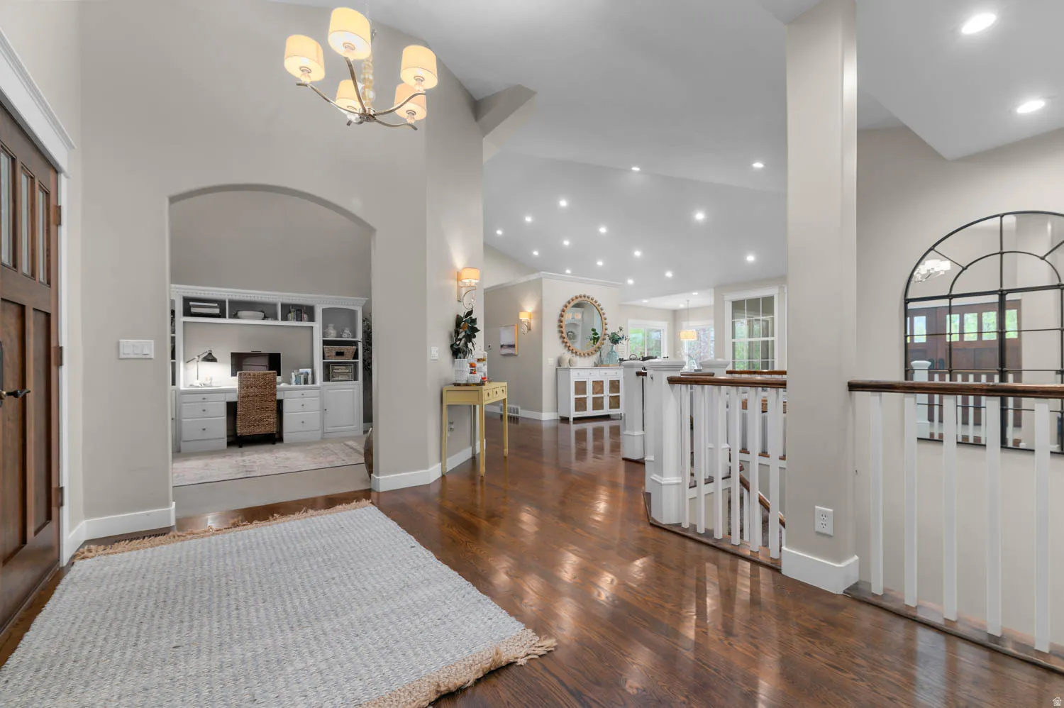 Entryway featuring dark wood-style flooring, hanging lights, and lofted ceiling