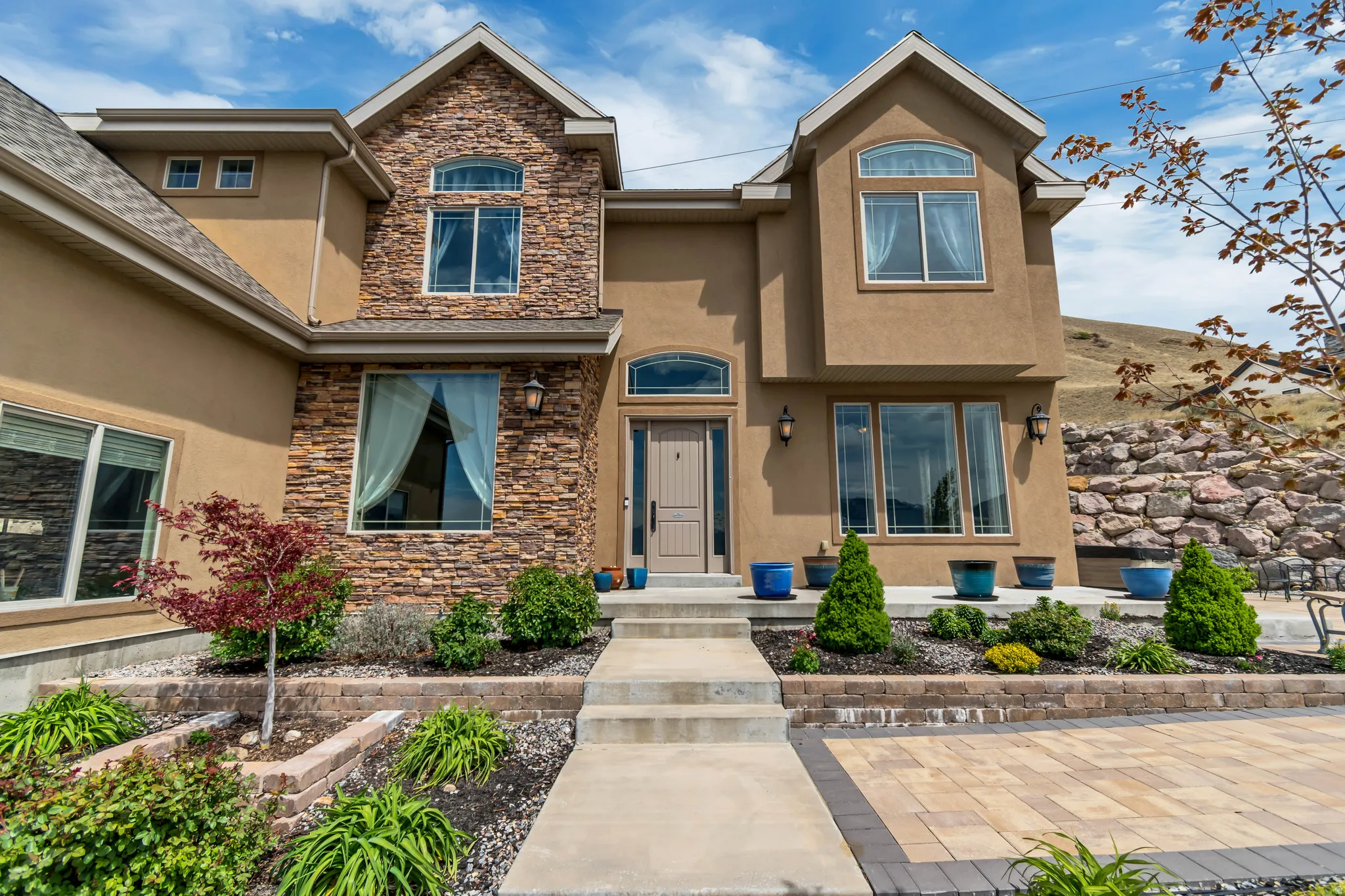 Property entrance with stone siding and stucco siding