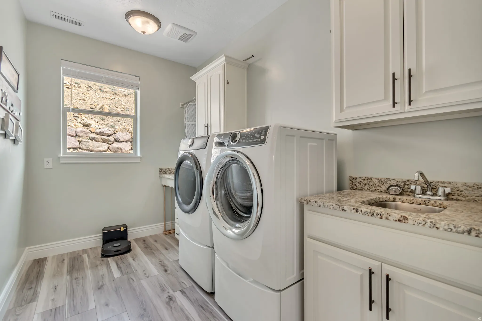 Laundry room with light wood finished floors, cabinet space, and separate washer and dryer