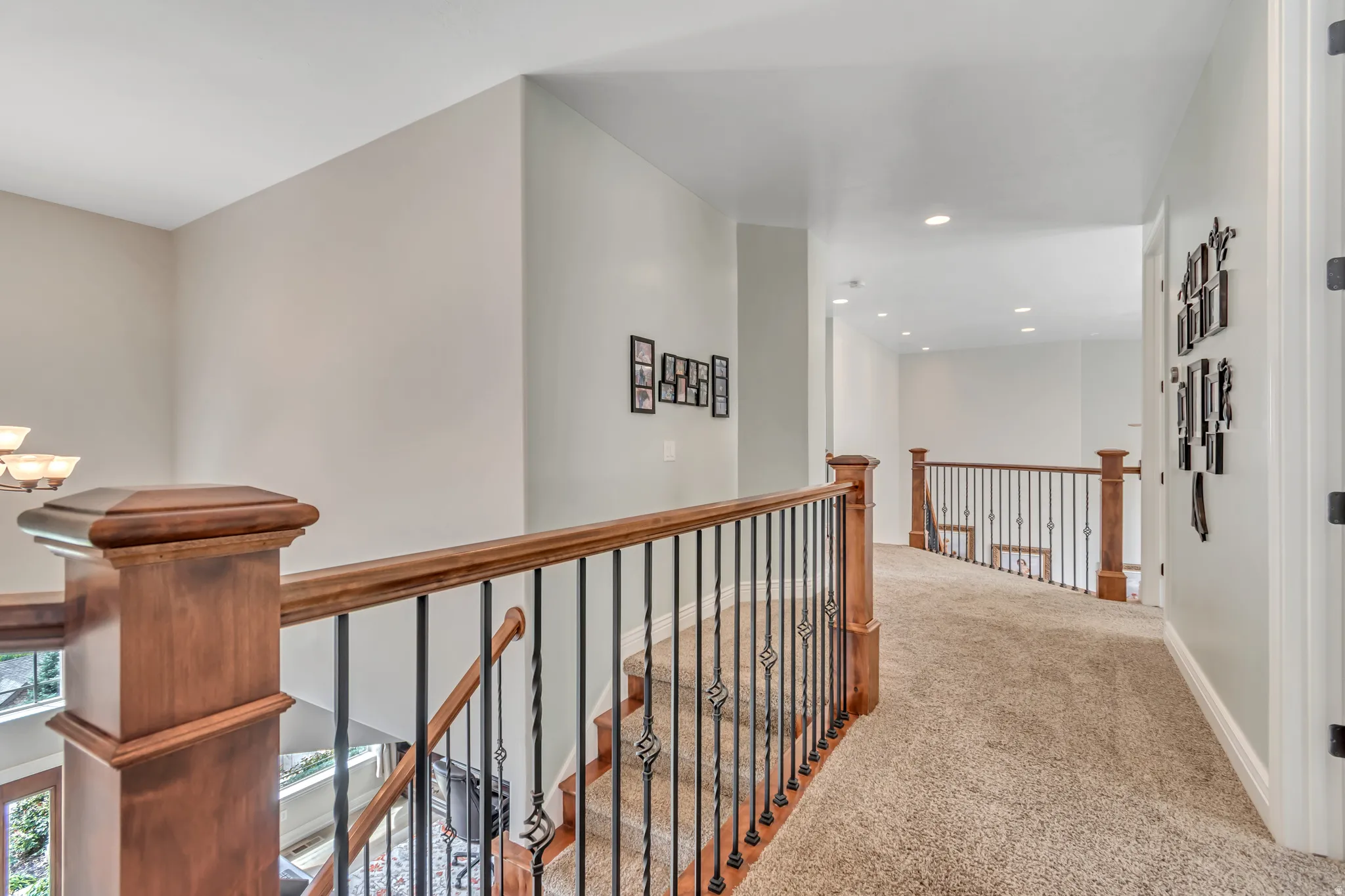 Hallway with carpet floors, an upstairs landing, and recessed lighting