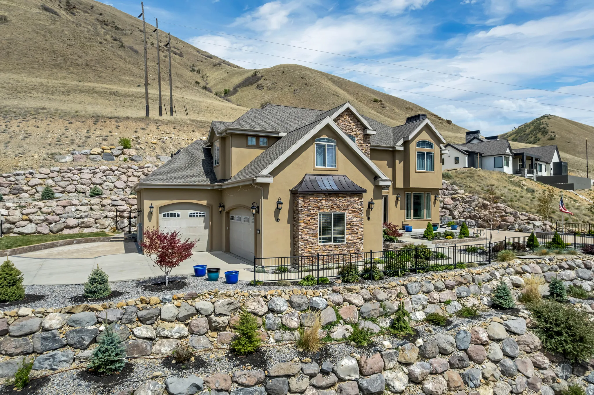Craftsman house featuring stucco siding, stone siding, a fenced front yard, a standing seam roof, and roof with shingles