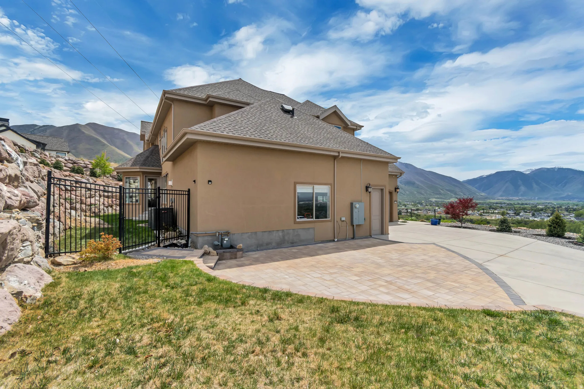 Rear view of house with a mountain view, stucco siding, roof with shingles, and a patio area