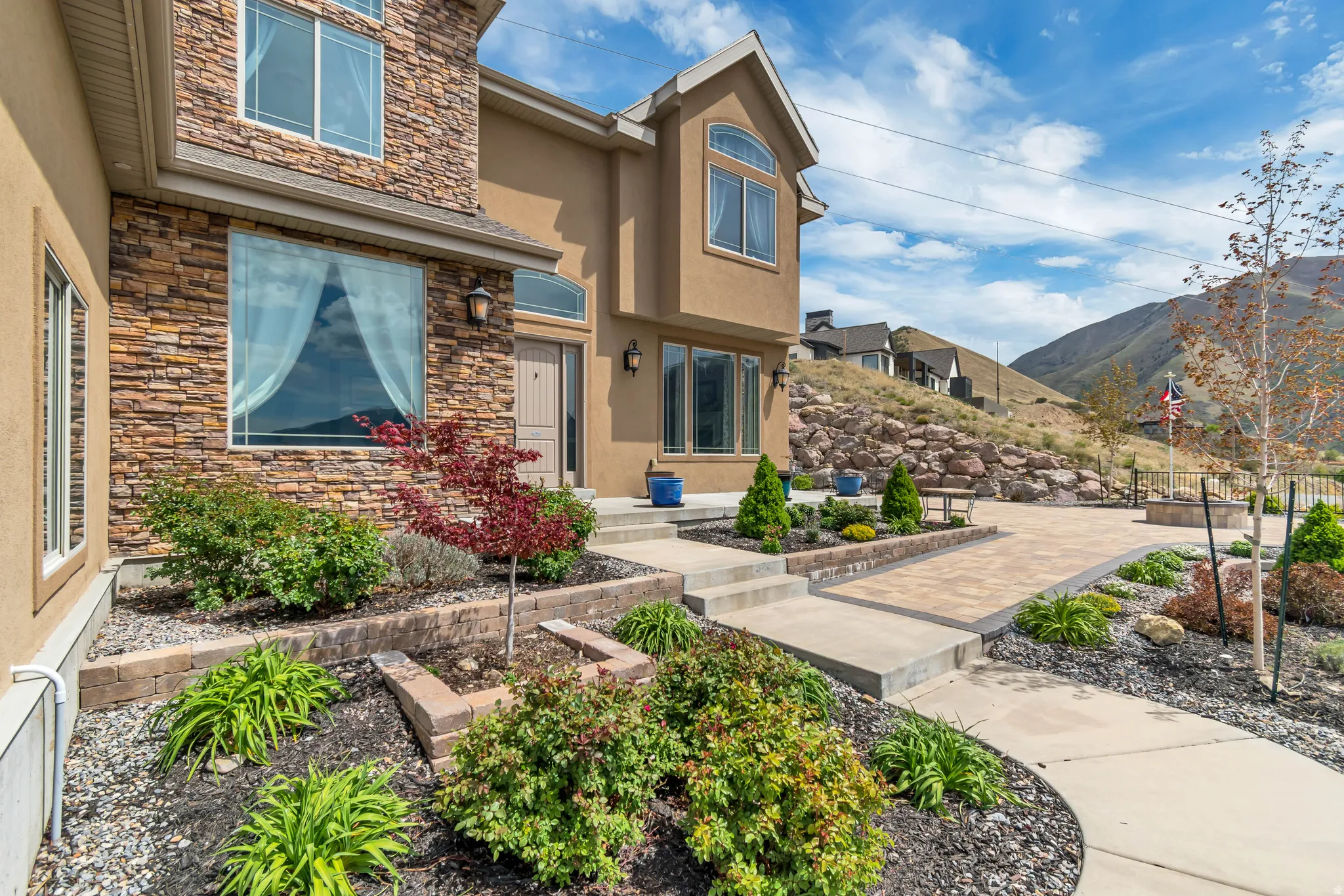 View of exterior entry featuring stone siding, stucco siding, and a mountain view
