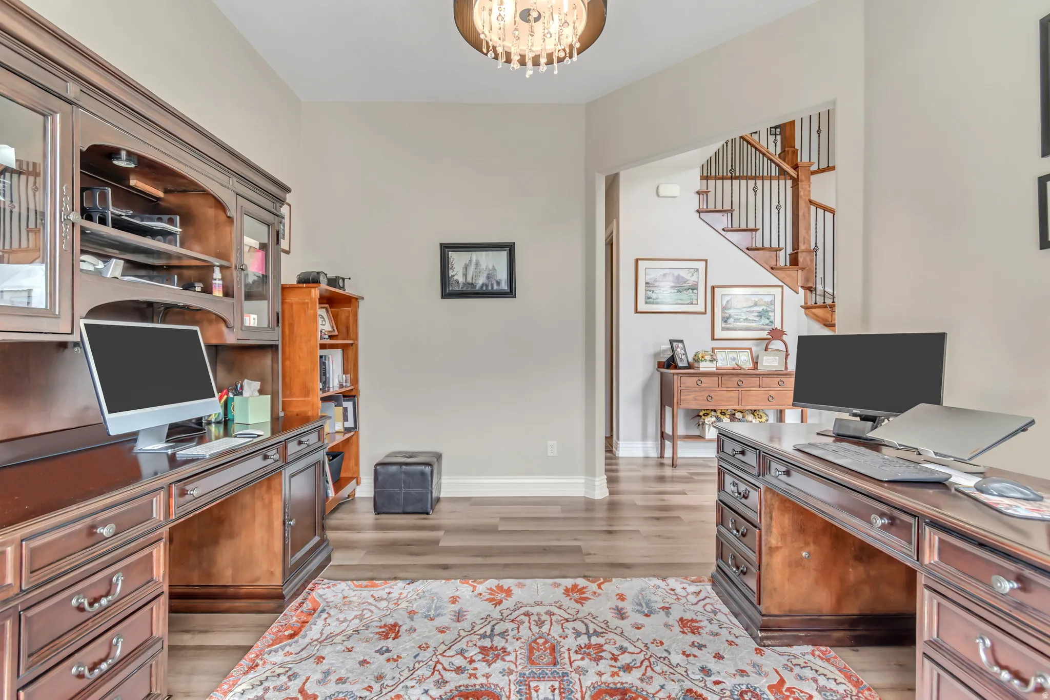 Office space featuring light wood-style floors, built in study area, and suspended lighting