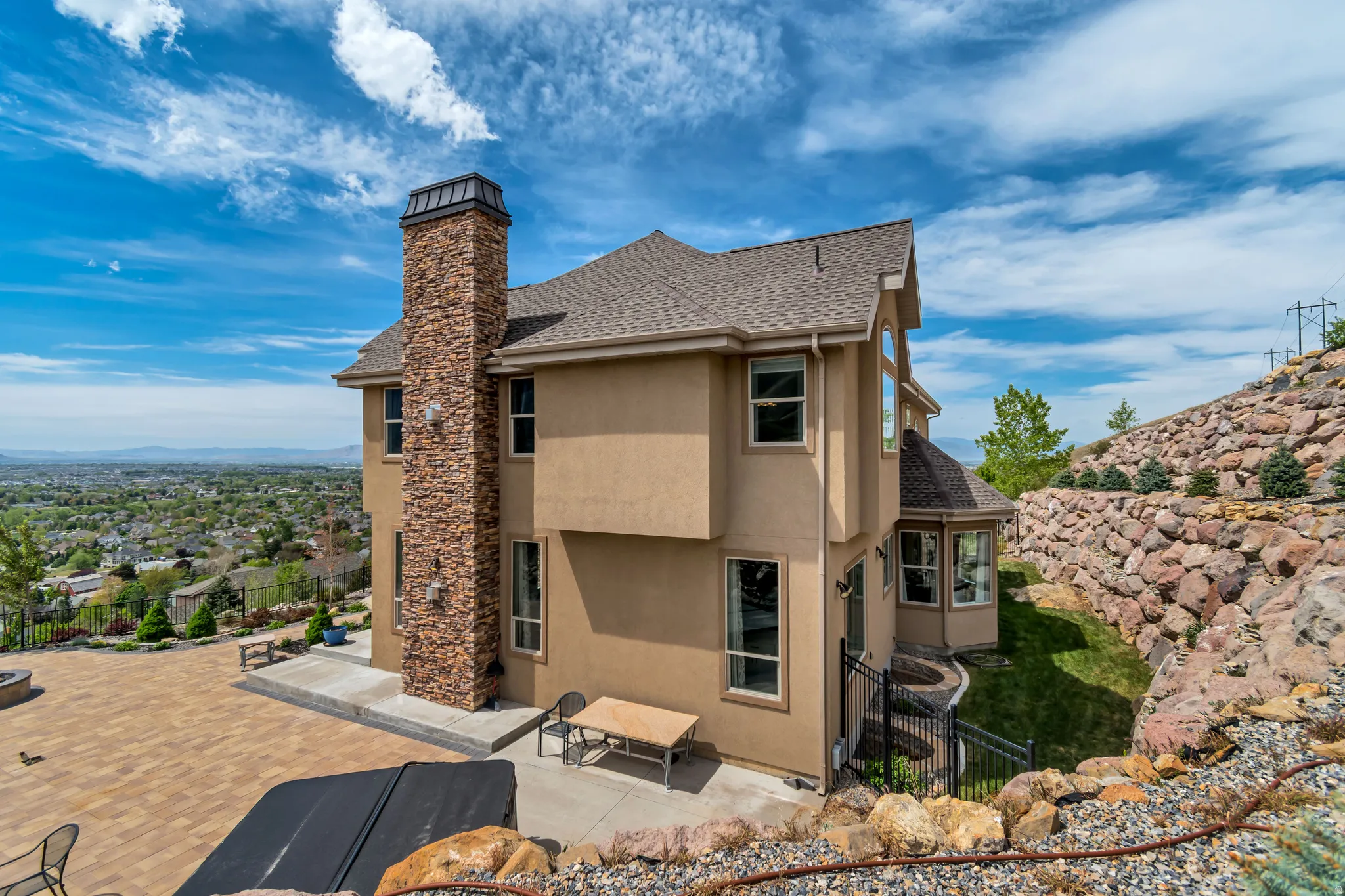 Back of house featuring a fenced backyard, stucco siding, roof with shingles, and a chimney
