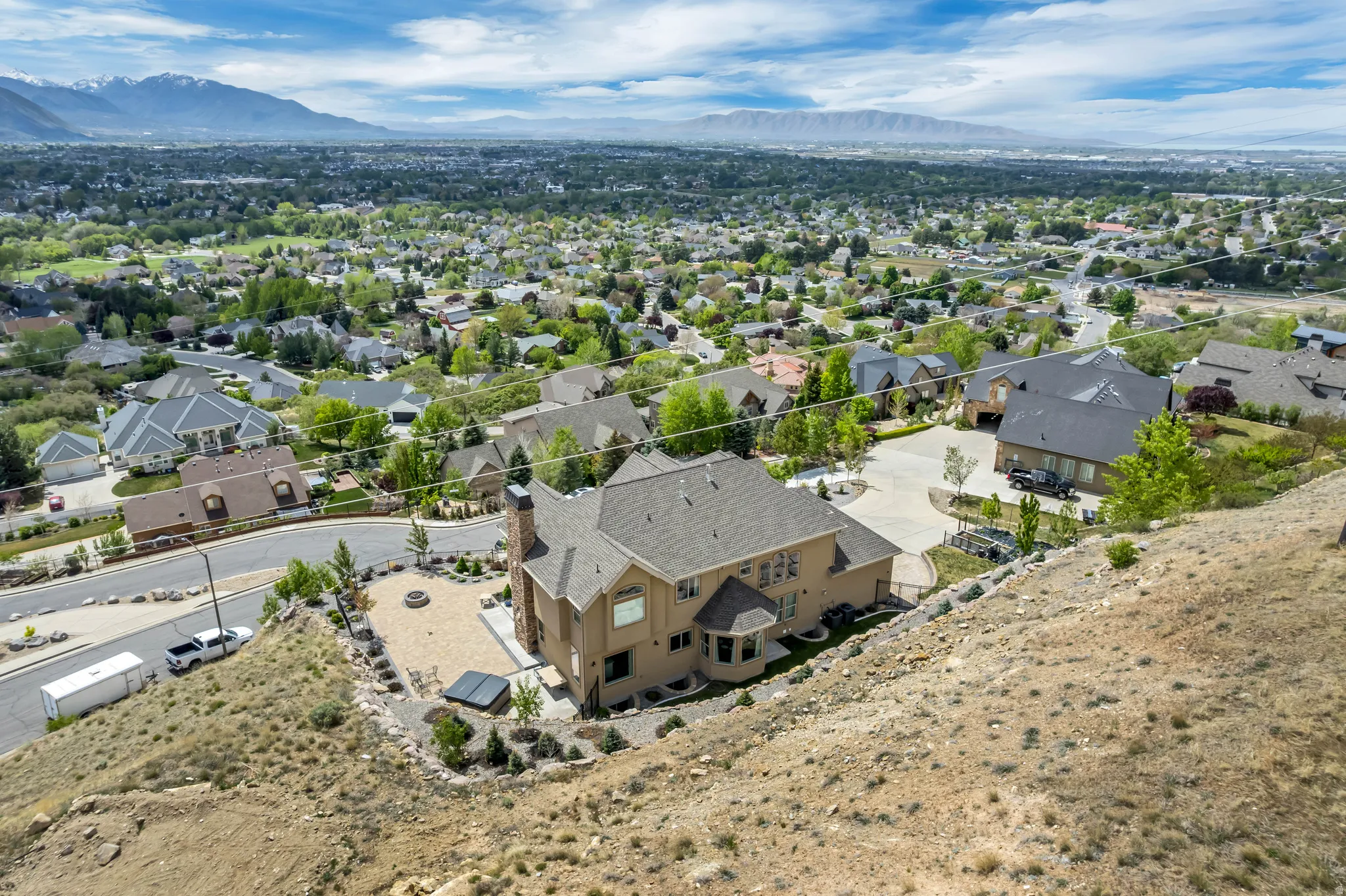 Aerial view of residential area with property boundaries highlighted and a mountain backdrop