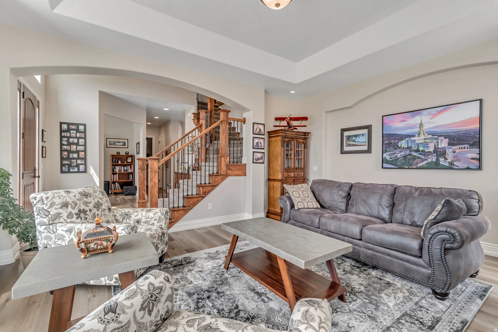 Living room with arched walkways and wood finished floors