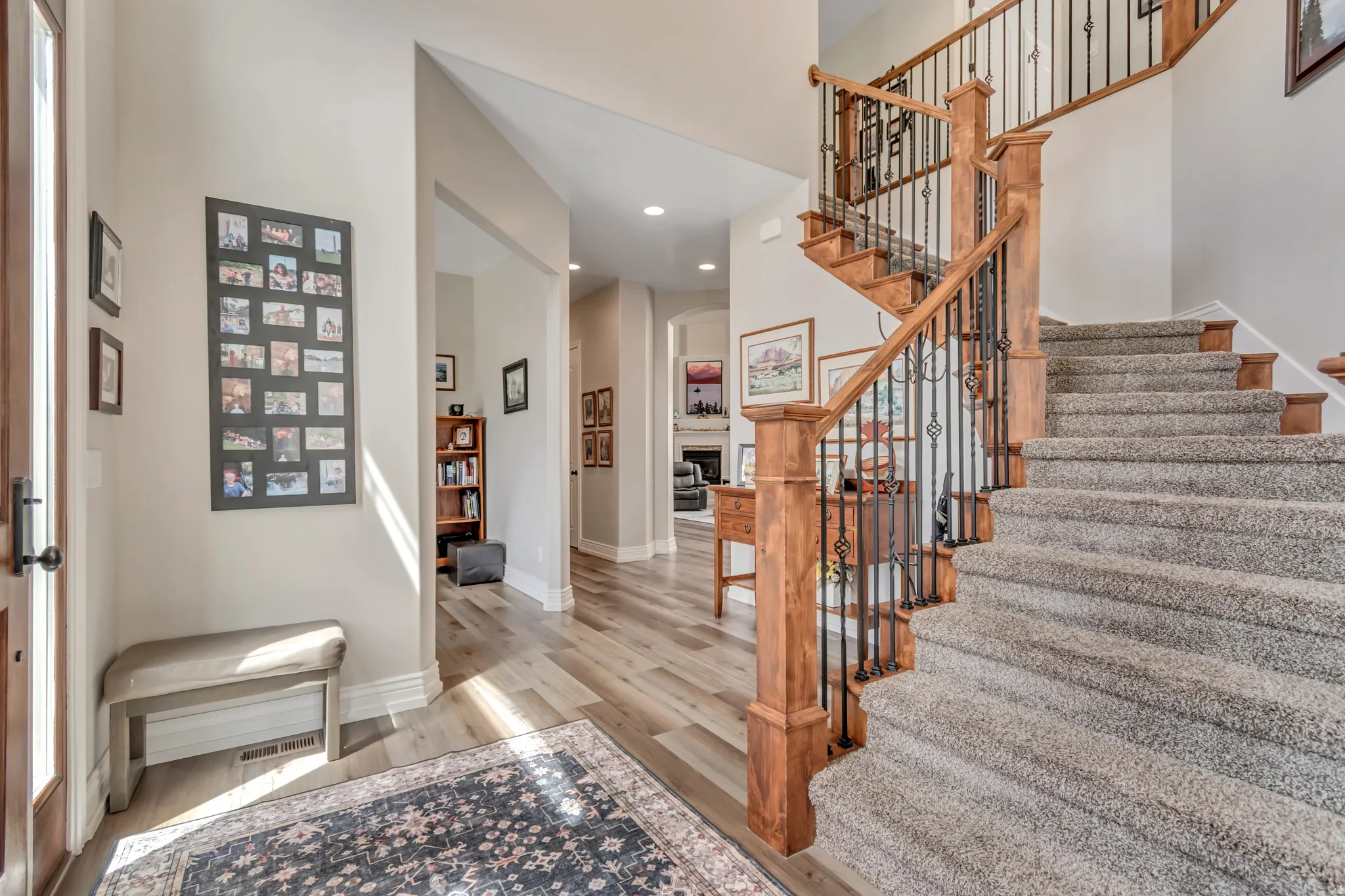 Foyer with light wood-style floors, recessed lighting, a fireplace, and a high ceiling