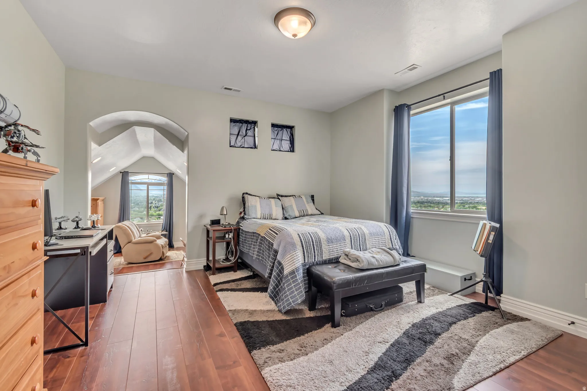 Bedroom with dark wood finished floors and vaulted ceiling