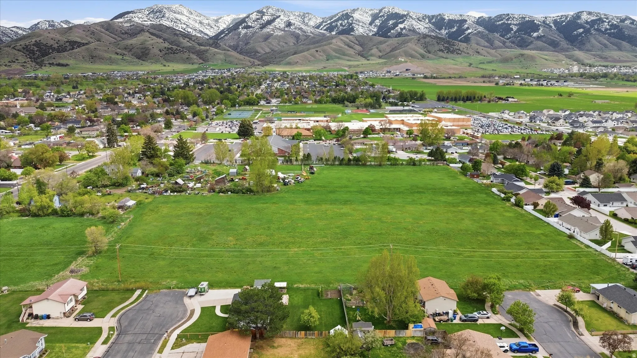 Aerial view of property and surrounding area featuring mountains and nearby suburban area