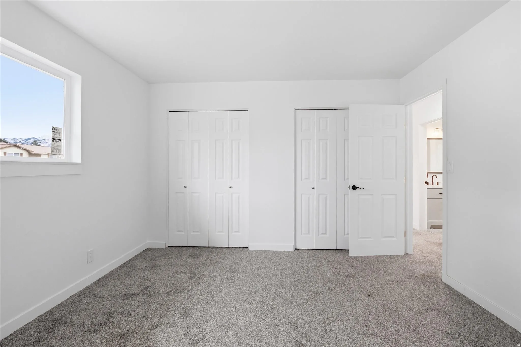 Unfurnished bedroom with two closets and carpet